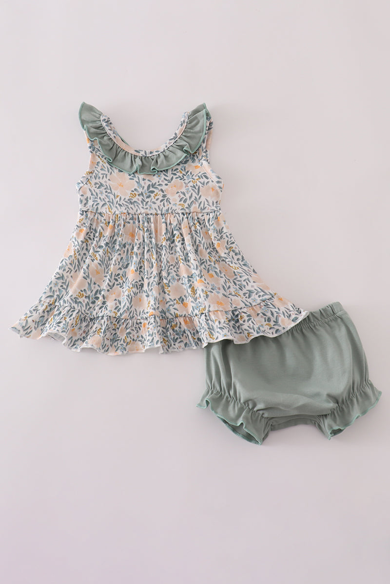 Floral dress and green bloomers set on a light gray background