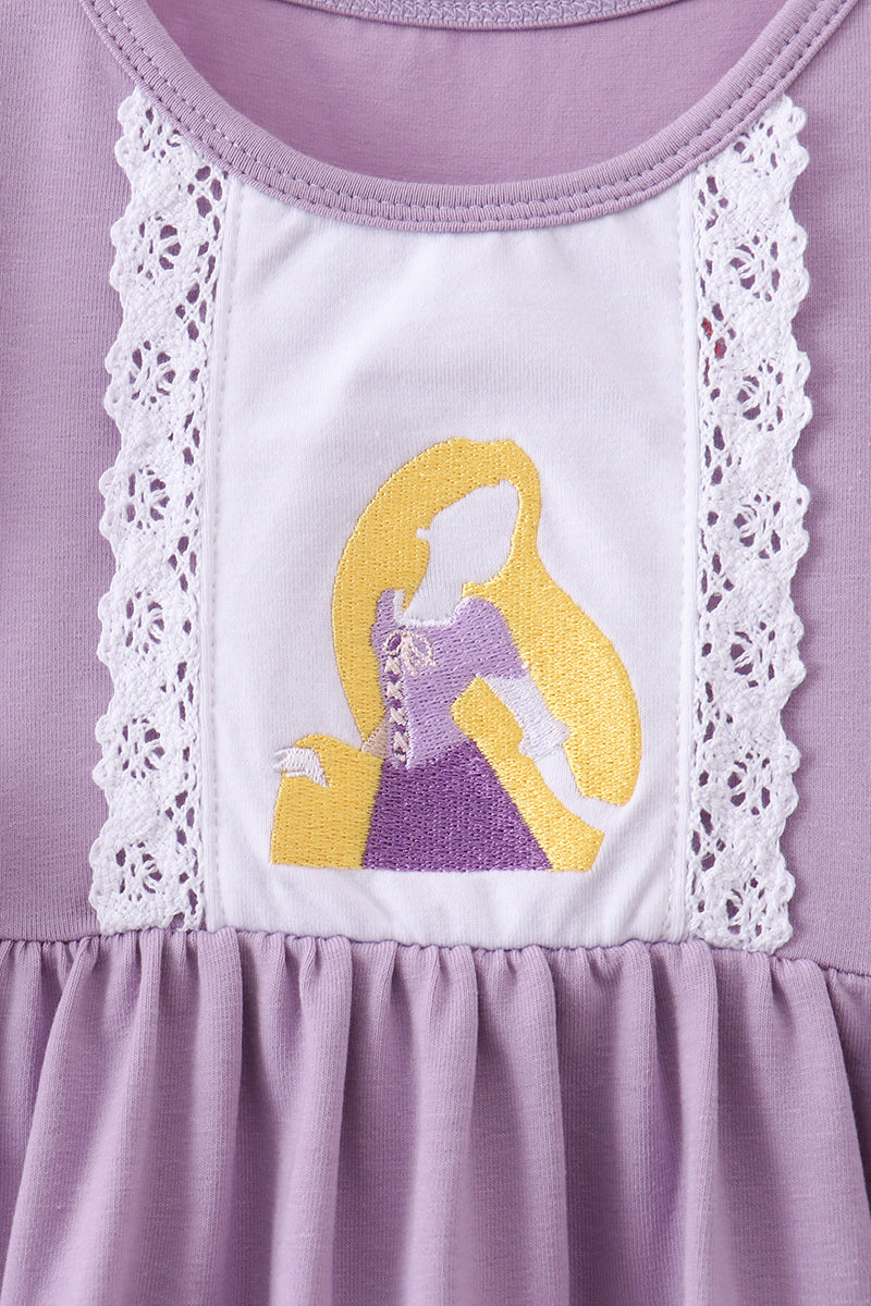 Close-up of a lavender and white dress featuring a white lace panel with an embroidered Disney Rapunzel character on the chest.