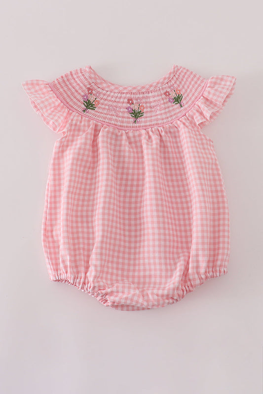 Pink checkered baby romper with floral embroidery on a light gray background