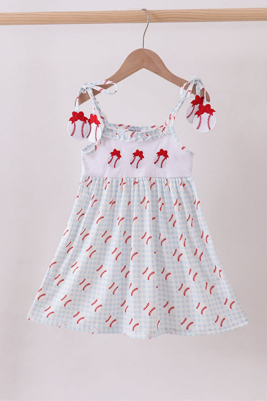 White dress with red bow pattern on a hanger against a beige background