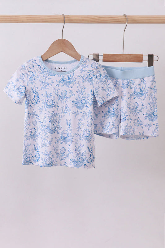 Children's blue floral pajama set on hangers against a light gray background
