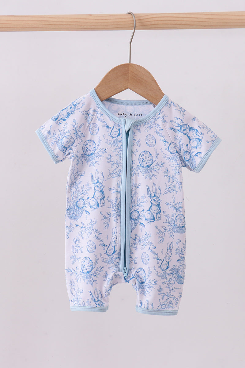 Baby romper with blue animal print hanging on a wooden hanger against a white background