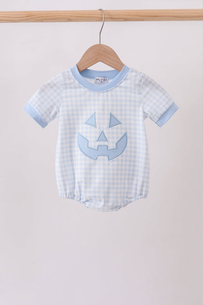 A baby short-sleeve romper in a light blue and white gingham pattern, featuring a light blue pumpkin face applique on the front and light blue ribbed trim, hanging on a wooden hanger.