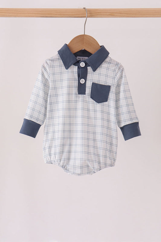 A baby long-sleeve polo romper with a light blue and white plaid pattern, featuring solid navy blue collar, cuffs, and chest pocket, hanging on a wooden hanger.
