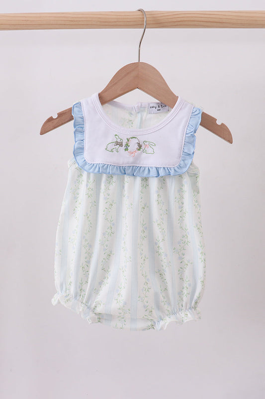 Baby romper with floral design on a wooden hanger against a light background