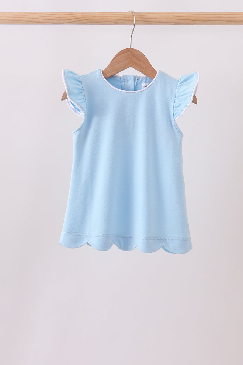 A light blue sleeveless top with ruffled cap sleeves and a scalloped hem, hanging on a wooden hanger from a wooden clothes rack against a plain light background.