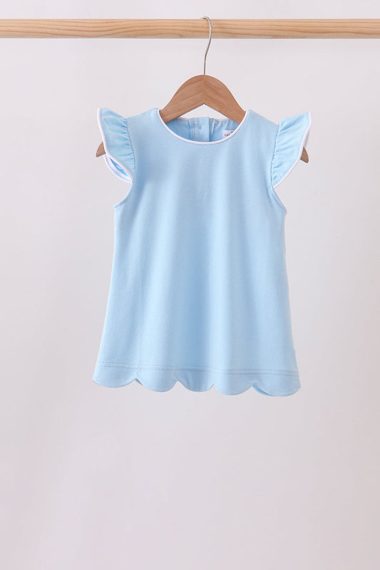 A light blue sleeveless top with ruffled cap sleeves and a scalloped hem, hanging on a wooden hanger from a wooden clothes rack against a plain light background.