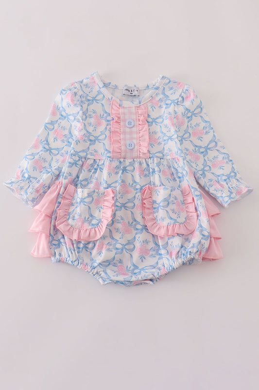Baby romper with floral pattern and ruffles on a light gray background