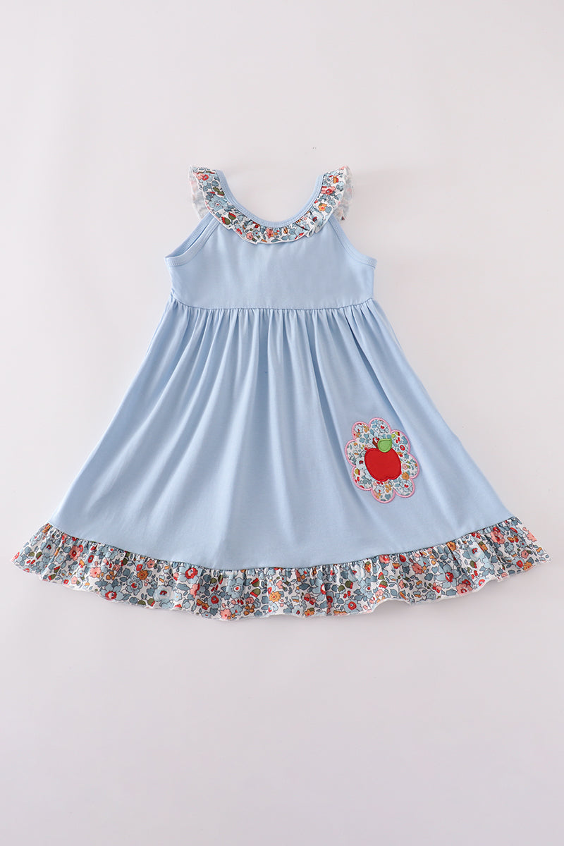 Light blue dress with floral details on a plain background