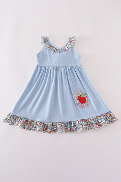 Light blue dress with floral details on a plain background