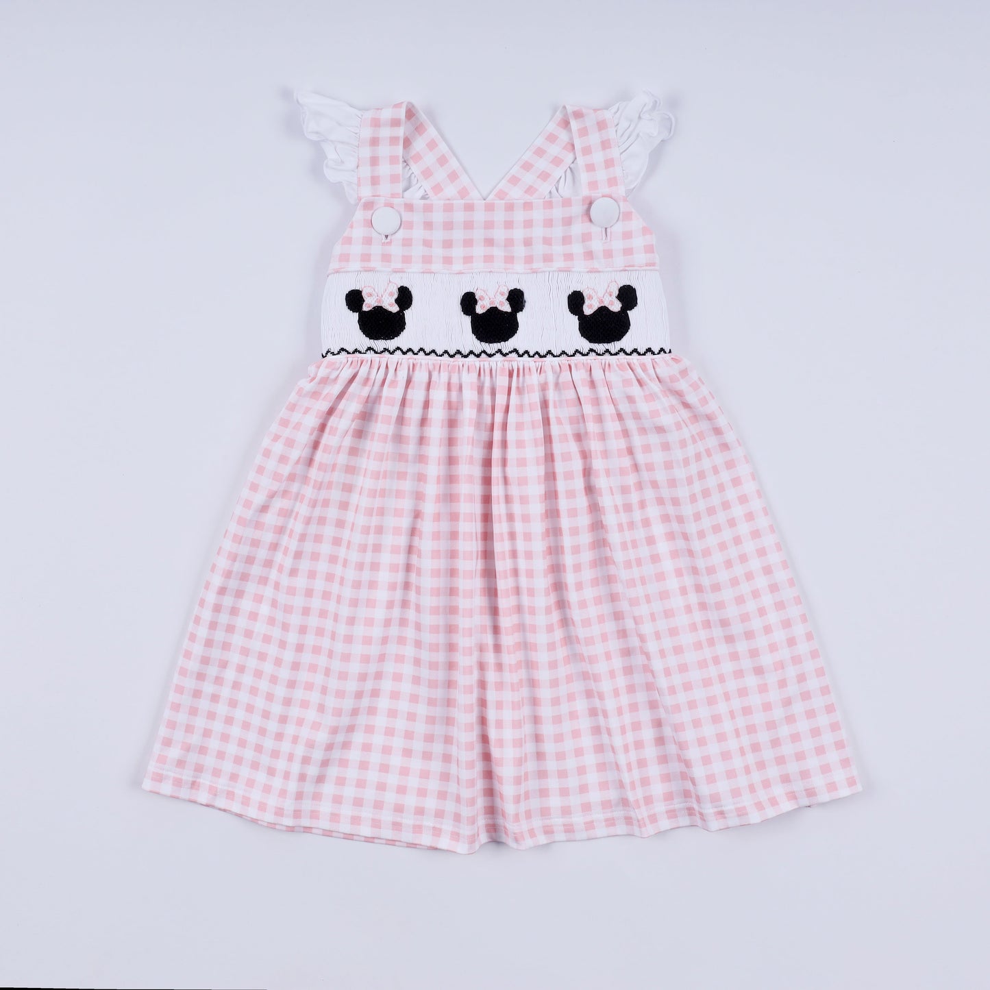 Pink checkered dress with embroidered details on a light gray background
