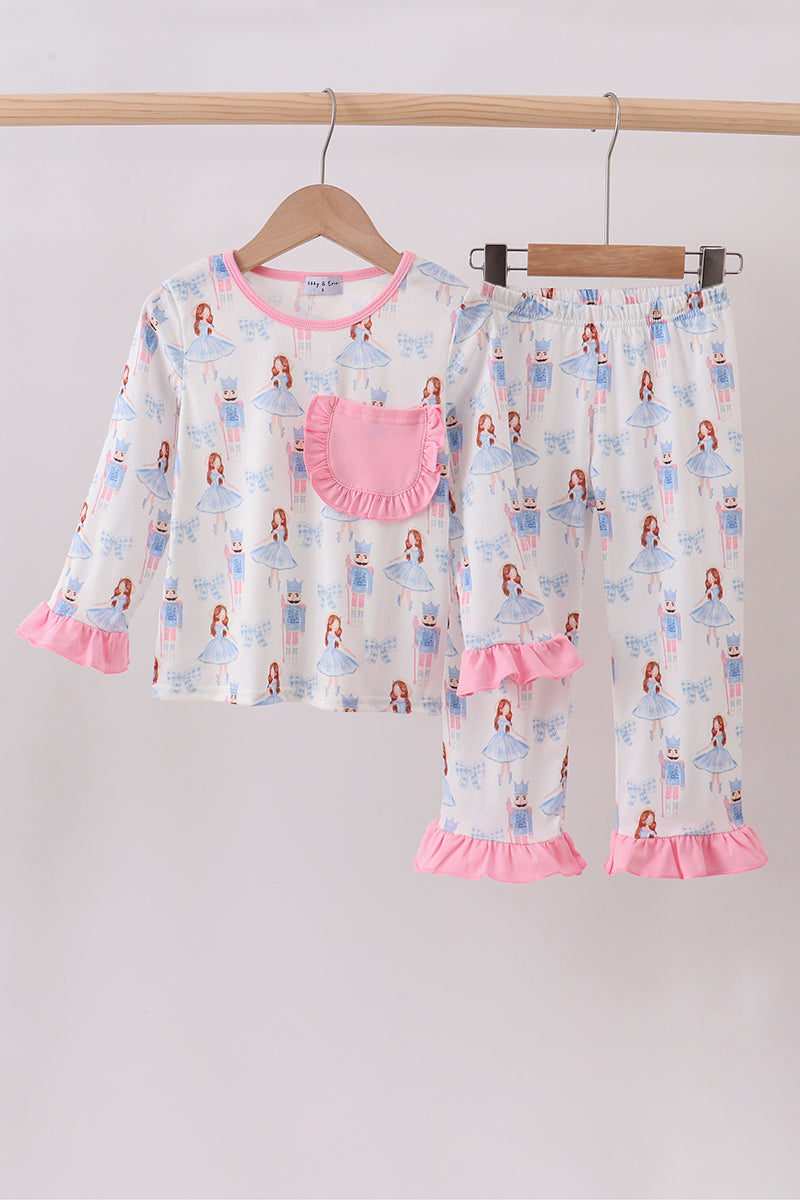 Children's pajama set with pink ruffles on a wooden hanger against a light gray background