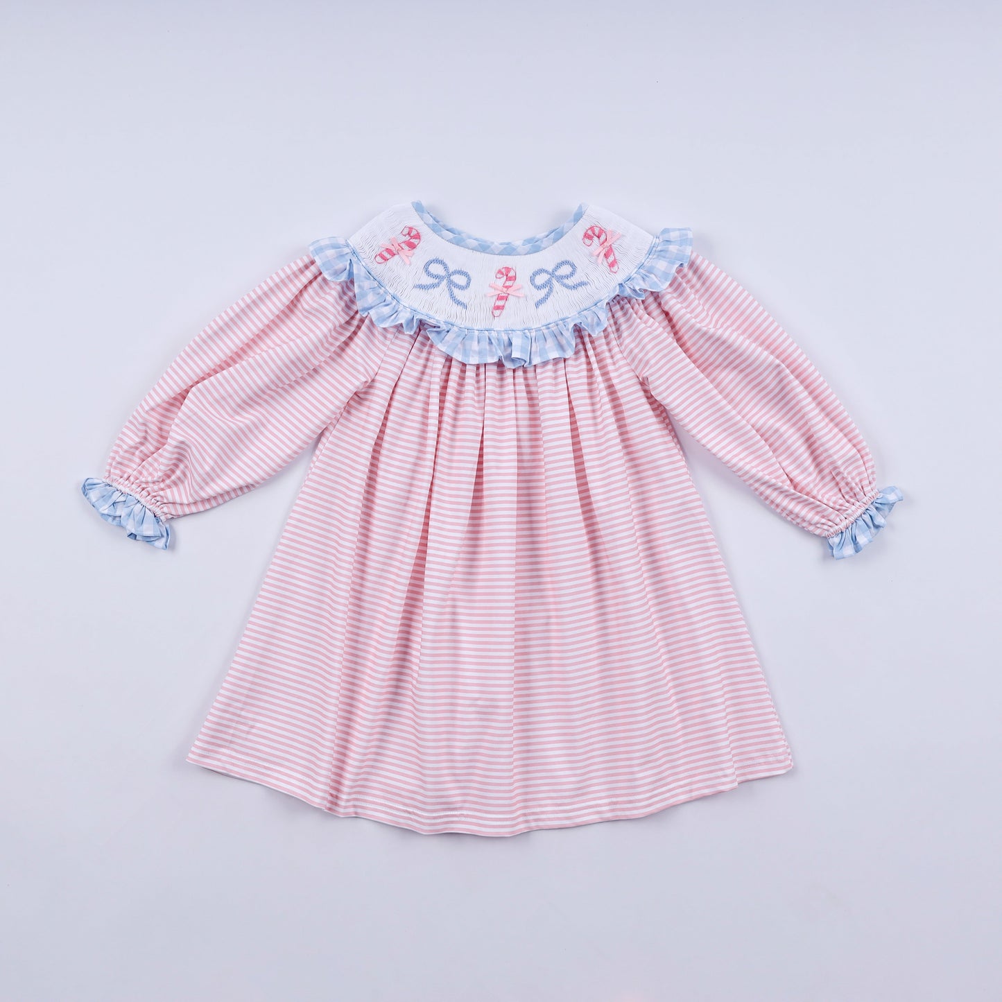 Pink and white striped dress with blue ruffled details on a light gray background