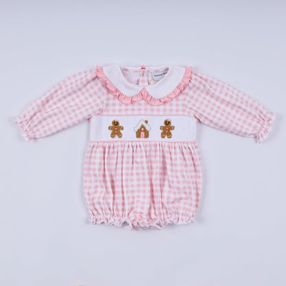 Pink checkered baby romper with teddy bear design on a light gray background