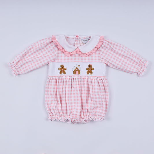 Pink checkered baby romper with teddy bear design on a light gray background