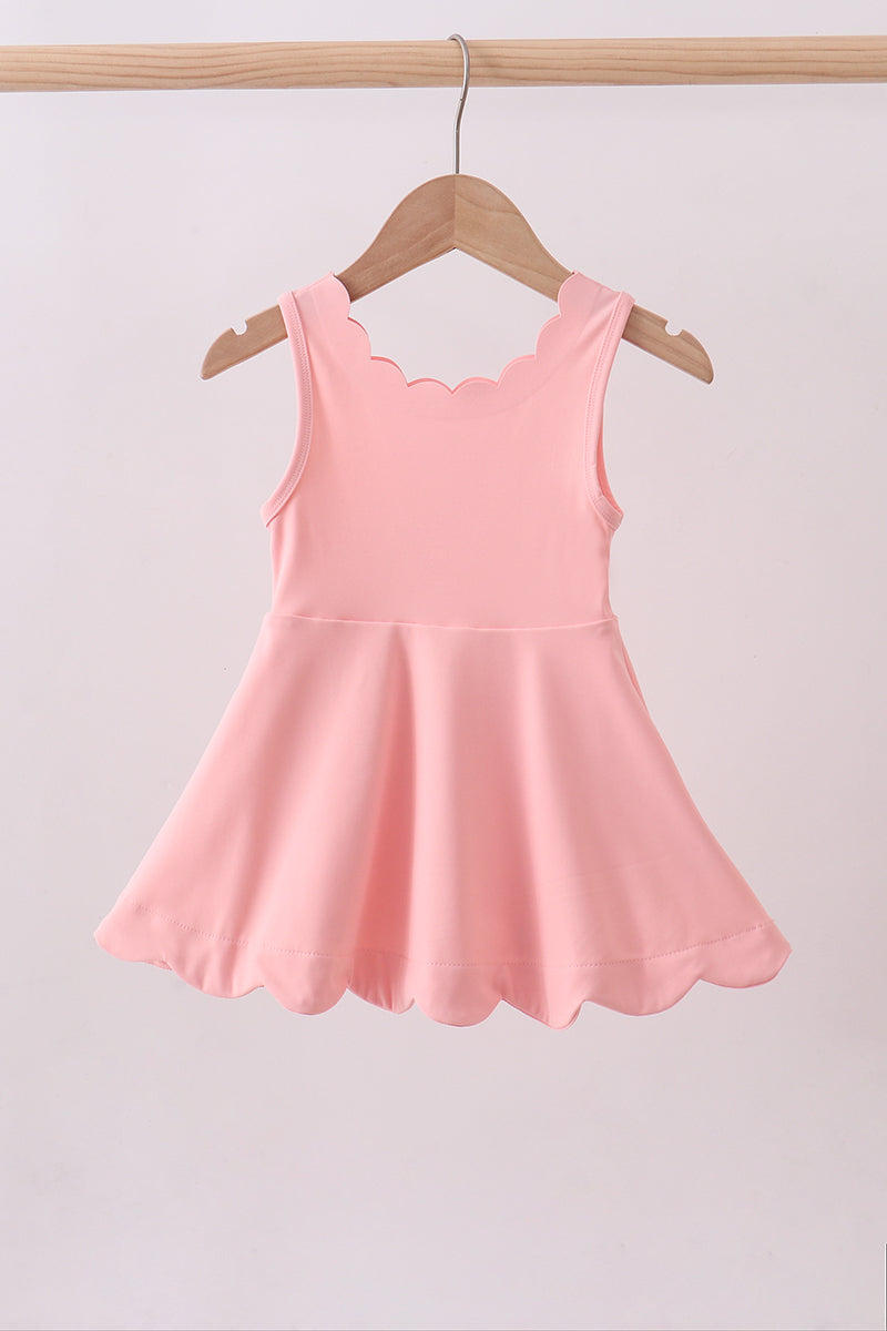 Pink dress on a hanger against a light gray background