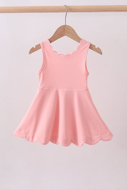 Pink dress on a hanger against a light gray background