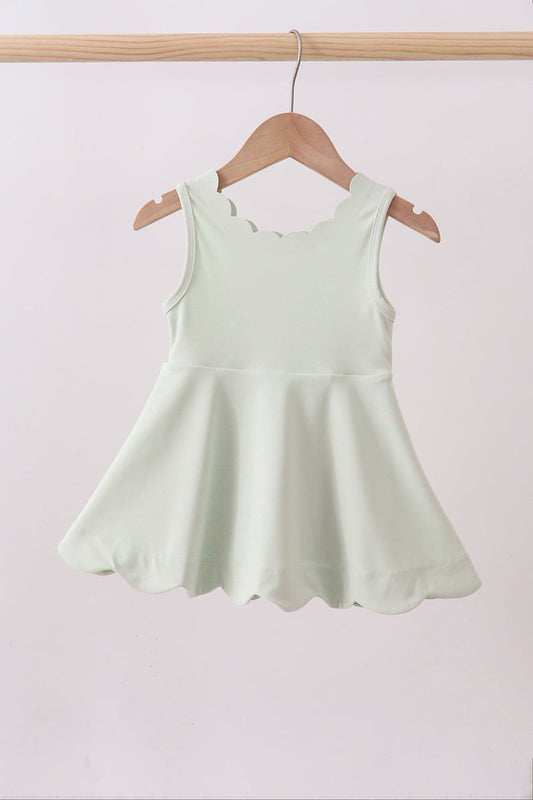 Light green dress on a wooden hanger against a white background