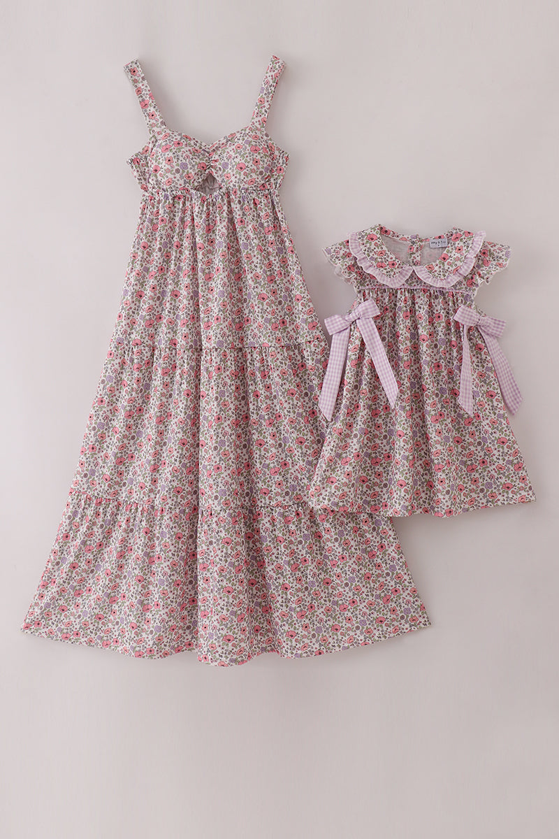Two floral dresses, one larger and one smaller, on a light gray background.