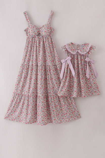 Two floral dresses, one larger and one smaller, on a light gray background.