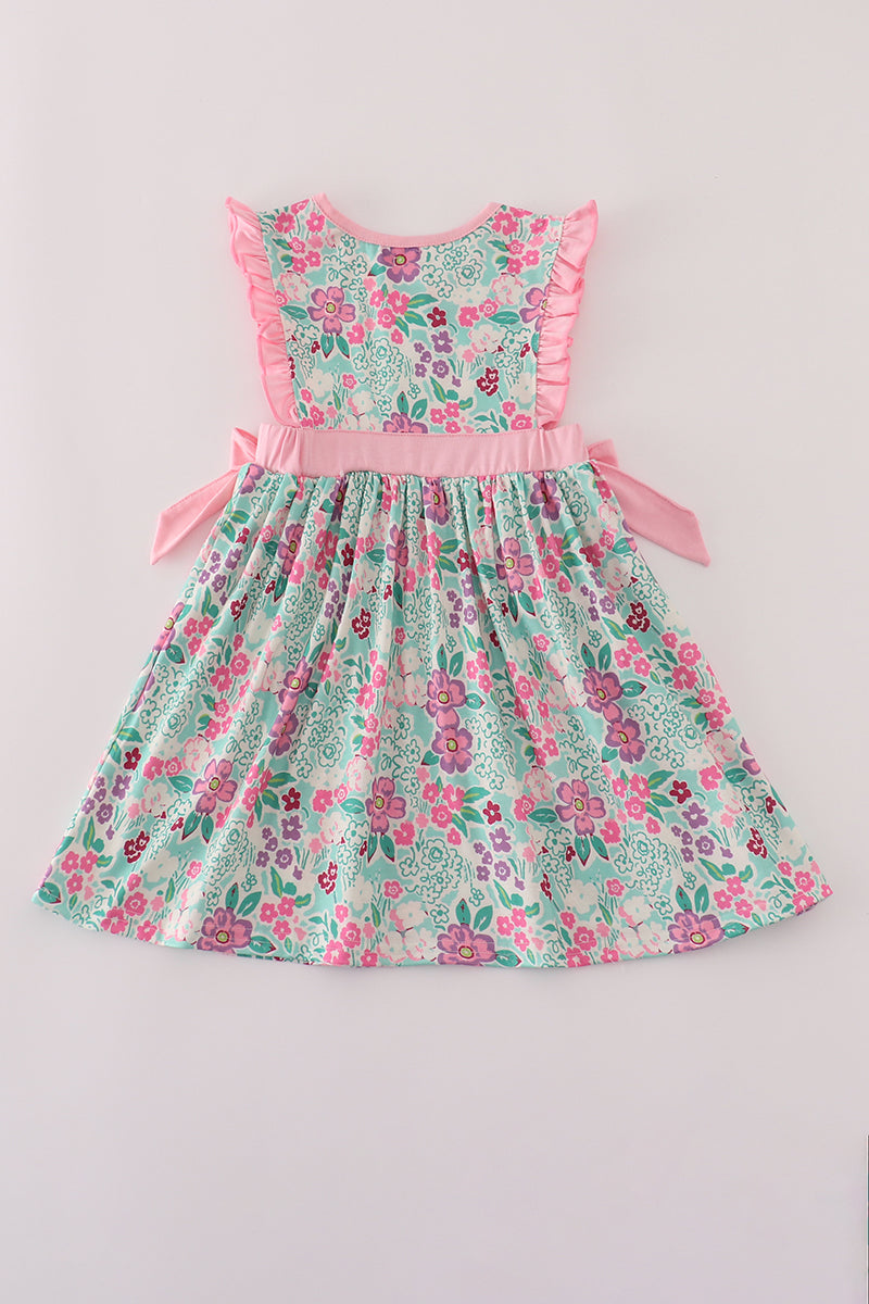 Floral dress with pink ruffled trim on a light gray background