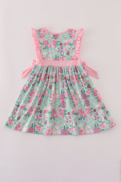 Floral dress with pink ruffled trim on a light gray background