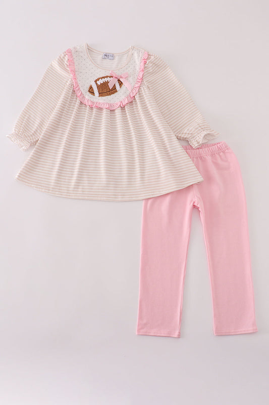 Children's outfit with striped top and pink pants on a light gray background